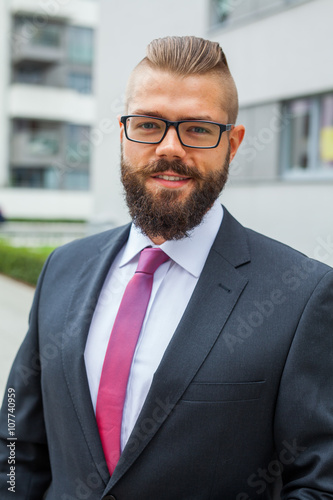 Portrait of a young happy businessman outside the office buildin