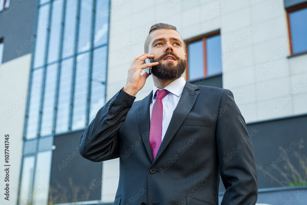 Young bearded businessman wearing eyeglasses using mobile phone Young bearded businessman wearing eyeglasses using mobile phone