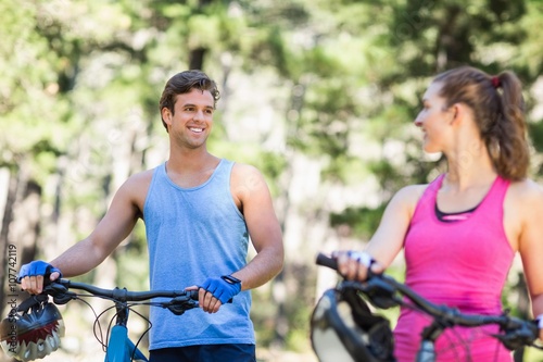 Happy man looking at woman with bicycles