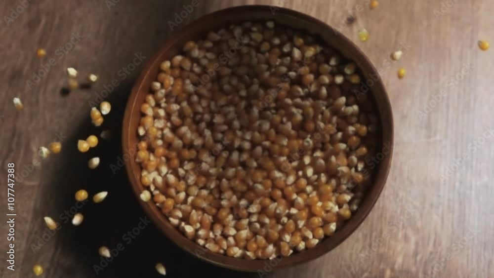 Woman's hand pouring pop corn into a bowl. Woman's hand pouring pop corn into a bowl.