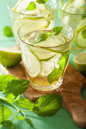 mojito cocktail and ingredients over green background