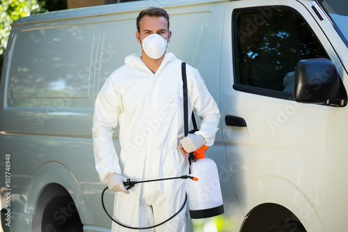 Portrait of pest control man standing next to a van