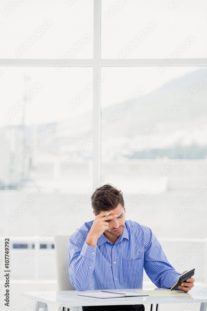 Businessman calculating accounts on a calculator Businessman calculating accounts on a calculator
