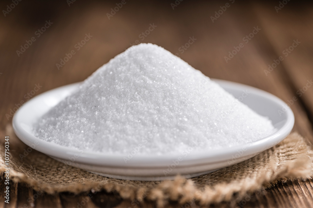 White Sugar (selective focus) on wooden background White Sugar (selective focus) on wooden background