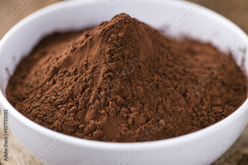 Cocoa powder on wooden background