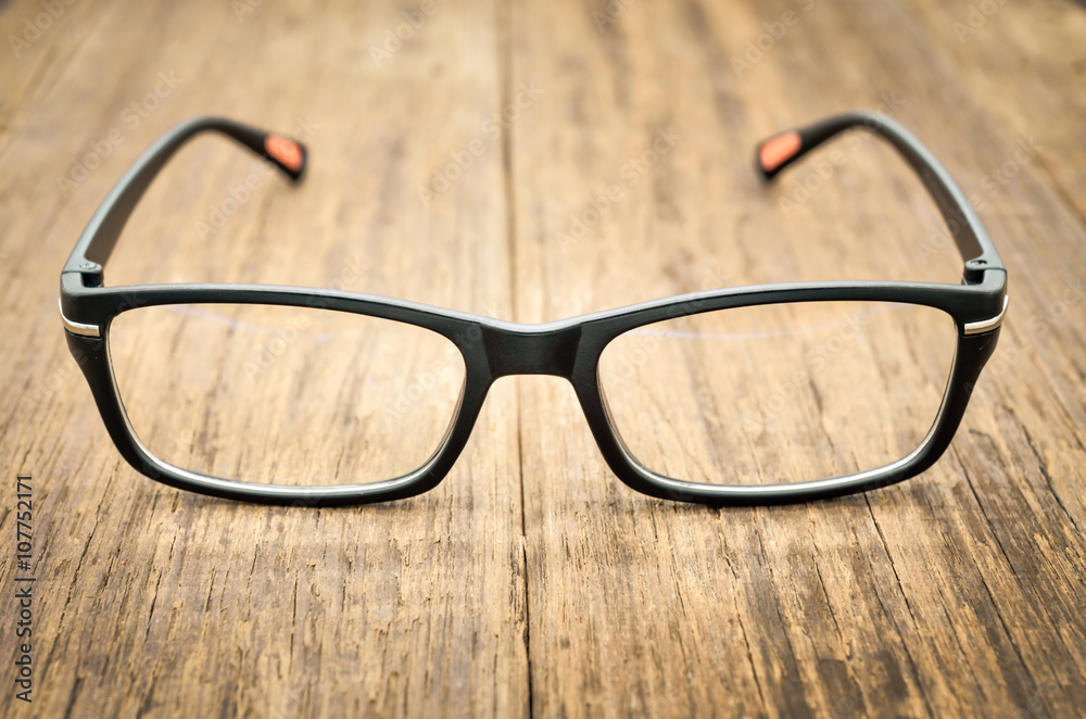 Black eye glasses on wooden floor, Close up image Black eye glasses on wooden floor, Close up image