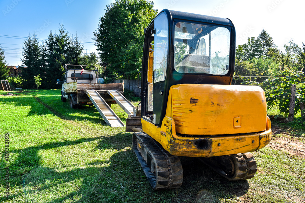 Loading excavator on a truck for transport. Loading excavator on a truck for transport.