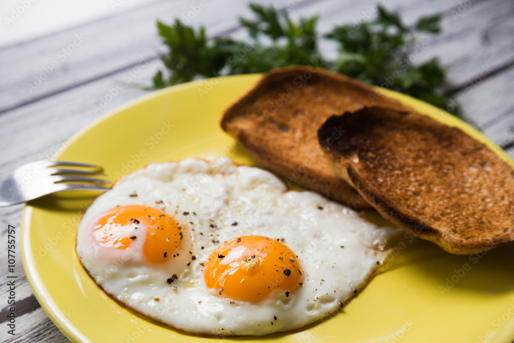 Fried eggs on a yellow plate