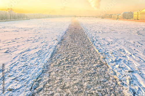 A view of frozen Neva river  from Dvortsovy bridge above a path made by an icebreaker   at a frosty hazy winter day