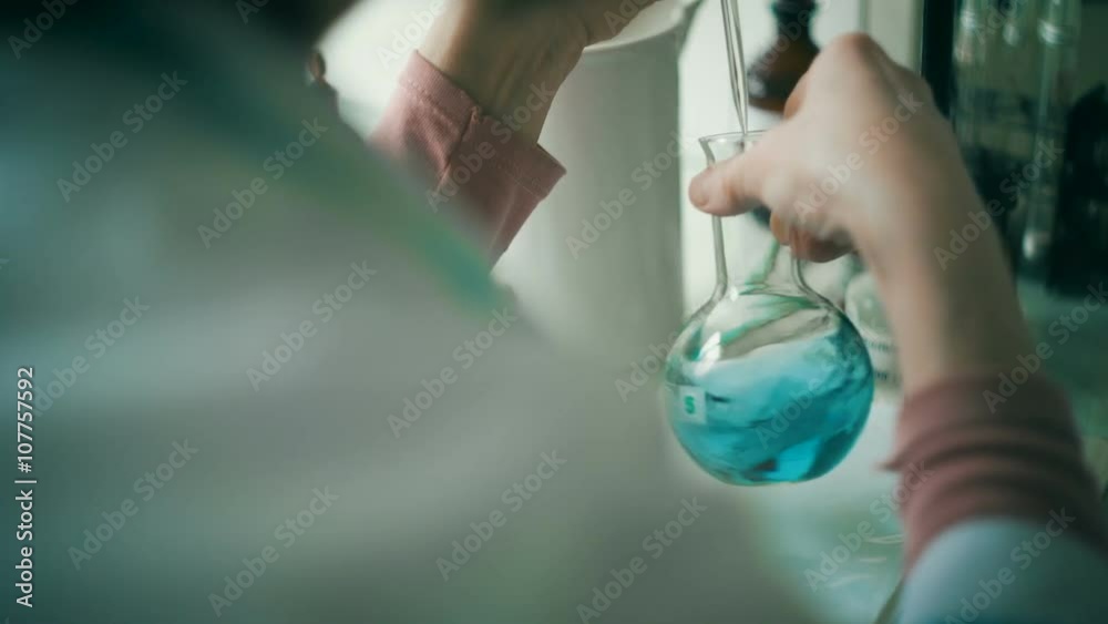 Woman working with flask in a laboratory 