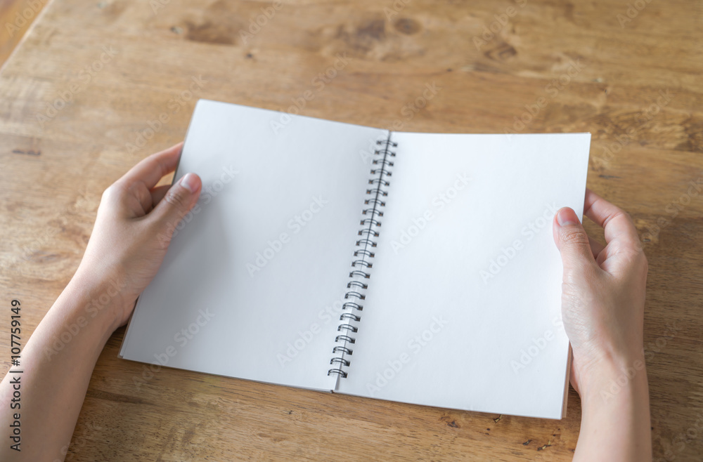 Hands open Blank catalog, magazines,book mock up on wood table Hands open Blank catalog, magazines,book mock up on wood table