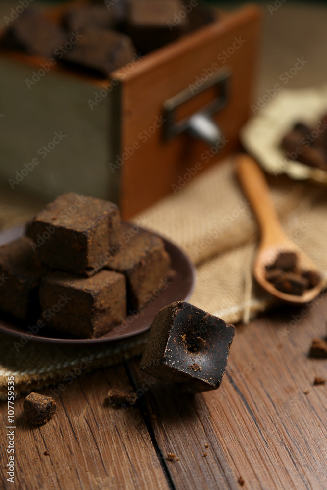 Brown sugar chunks in wooden boxes and plates Brown sugar chunks in wooden boxes and plates