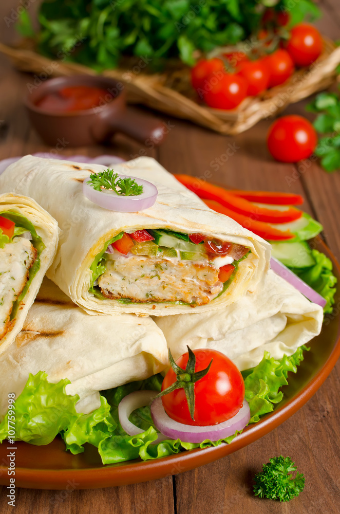 Fresh tortilla wraps with kebab and fresh vegetables on plate