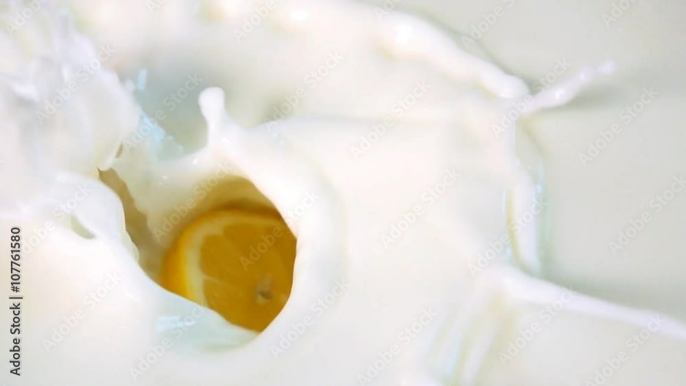 Pieces of lemon drops into the milk. Slowmotion Pieces of lemon drops into the milk. Slowmotion