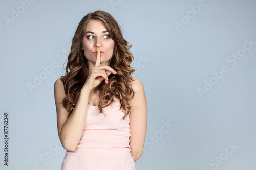 Secret woman. Female showing hand silence sign 