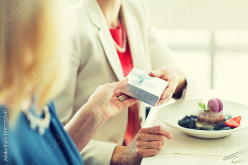 close up of women giving present at restaurant