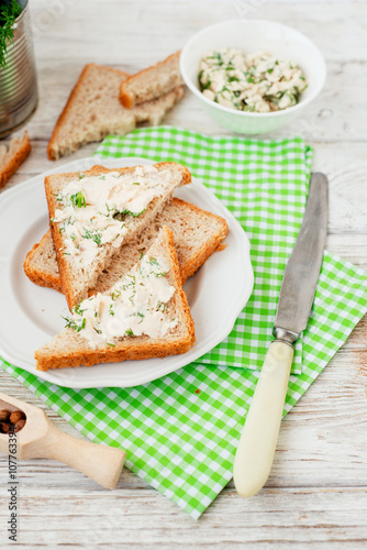 
breakfast or lunch , light sandwiches ,  rye toast with cream cheese , dill and spices on a wooden background
