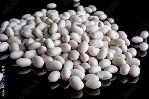 Scattered white beans on black background