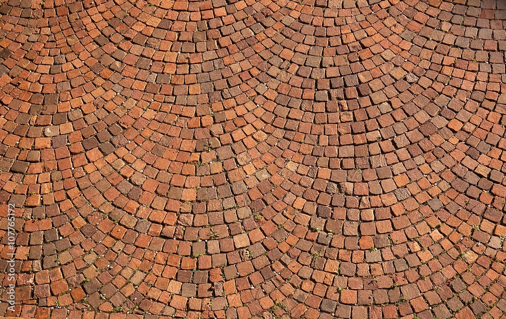 Fototapeta premium Closeup of brown radial stone pavement texture