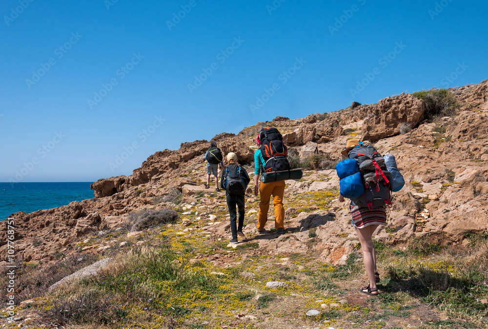 group of tourists with large backpacks are on road sea