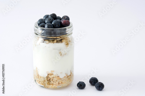 Yogurt with fresh blueberries and cereals on white background
