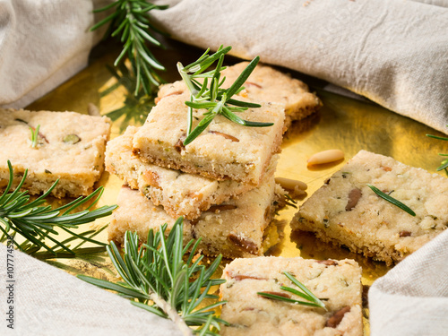 Cookies with rosemary and pignoli nuts on golden tray