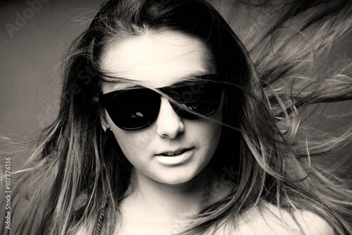 Junge Frau mit Sonnenbrille mit wehendem Haar