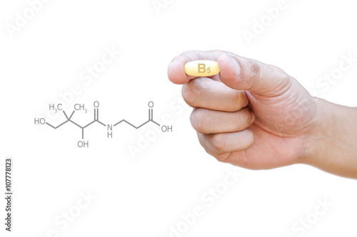 Hand holding vitamin B5 pill with clipping path