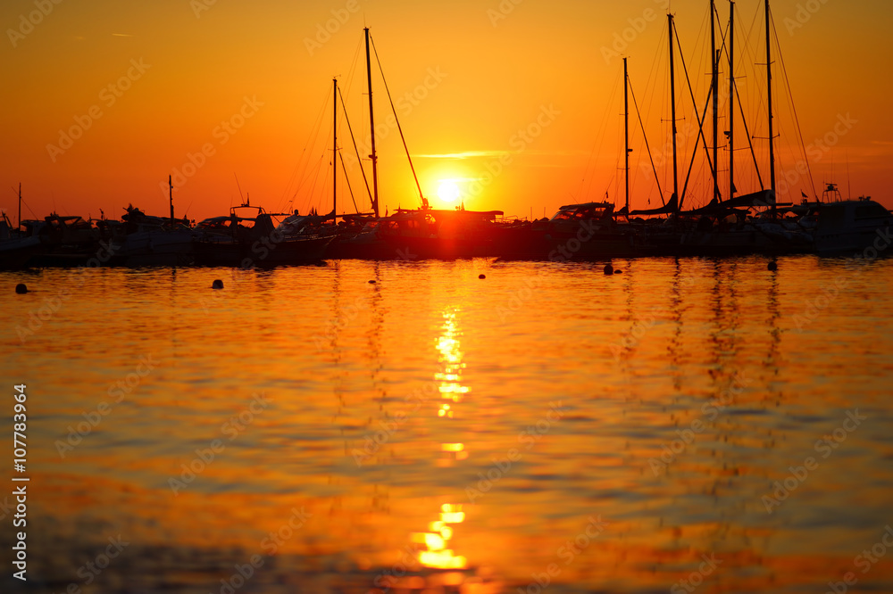 Yachts and boats at Adriatic sea bay at sunset in golden and pink tones in Salermo