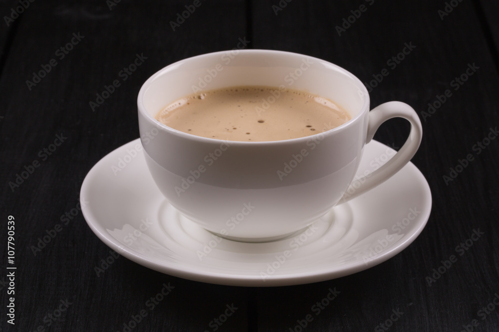 Cappuccino with cinnamon in a white cup. Coffee on Black Wooden Table