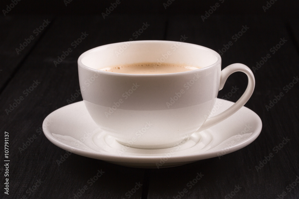 Fototapeta premium Cappuccino with cinnamon in a white cup. Coffee on Black Wooden Table