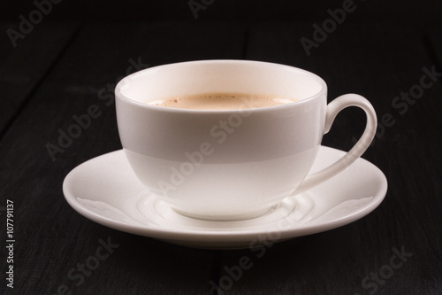 Cappuccino with cinnamon in a white cup. Coffee on Black Wooden Table