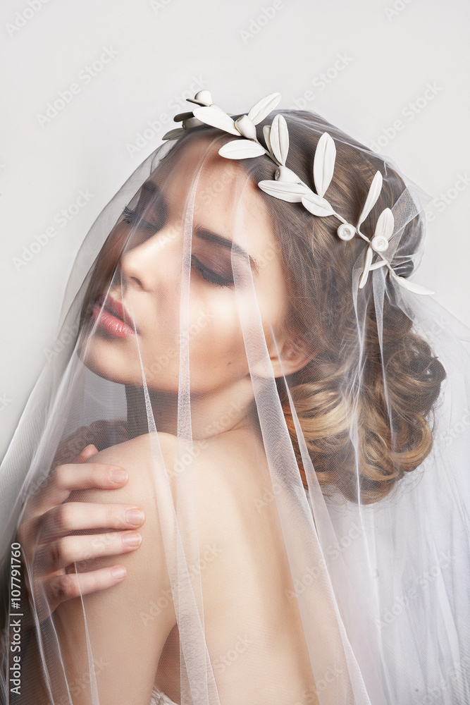 Naklejka premium Beautiful bride with fashion wedding hairstyle - on white background.Closeup portrait of young gorgeous bride. Wedding. Studio shot.Beautiful bride portrait with veil over her face