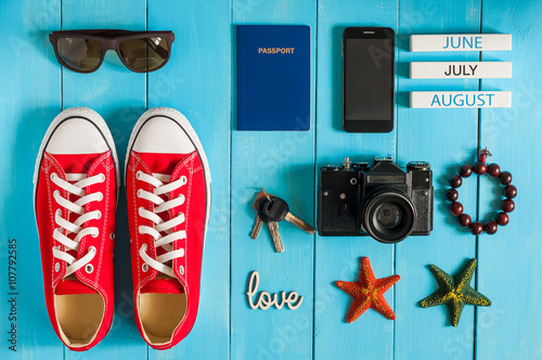 Summer outfit of traveler, student, teenager, girl, young woman or guy. Overhead Of essentials for modern Young person. Different objects on blue wooden background