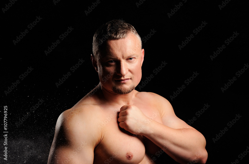 Muscular male posing on black background Muscular male posing on black background