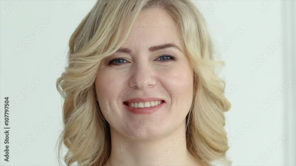 a woman with blond hair looking at the camera