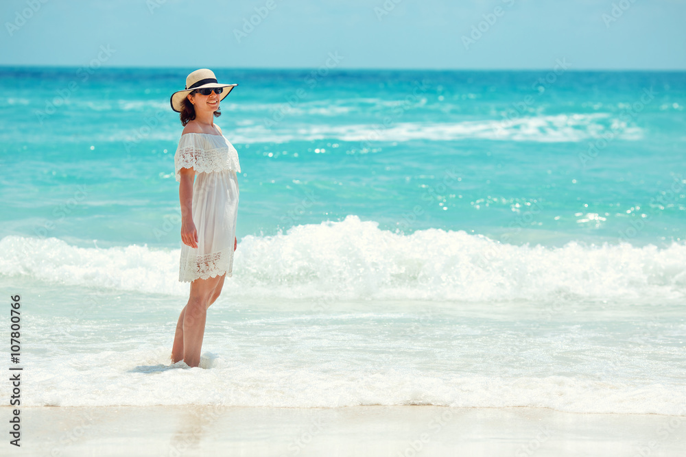 Woman in white dress walking on the beach