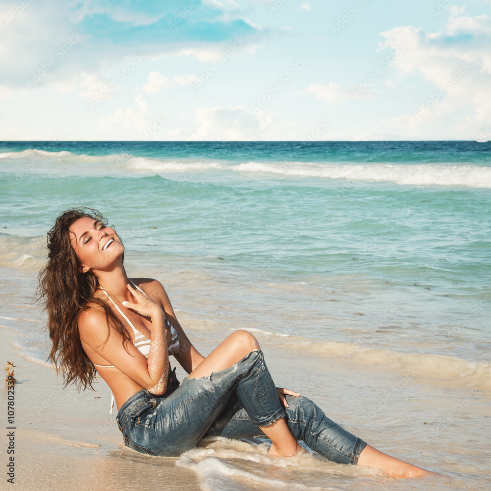 Young woman in wet jeans on the beach Stock Photo | Adobe Stock