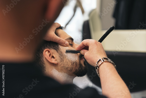 Bearded Man Getting Beard Haircut With A Razor By Barber