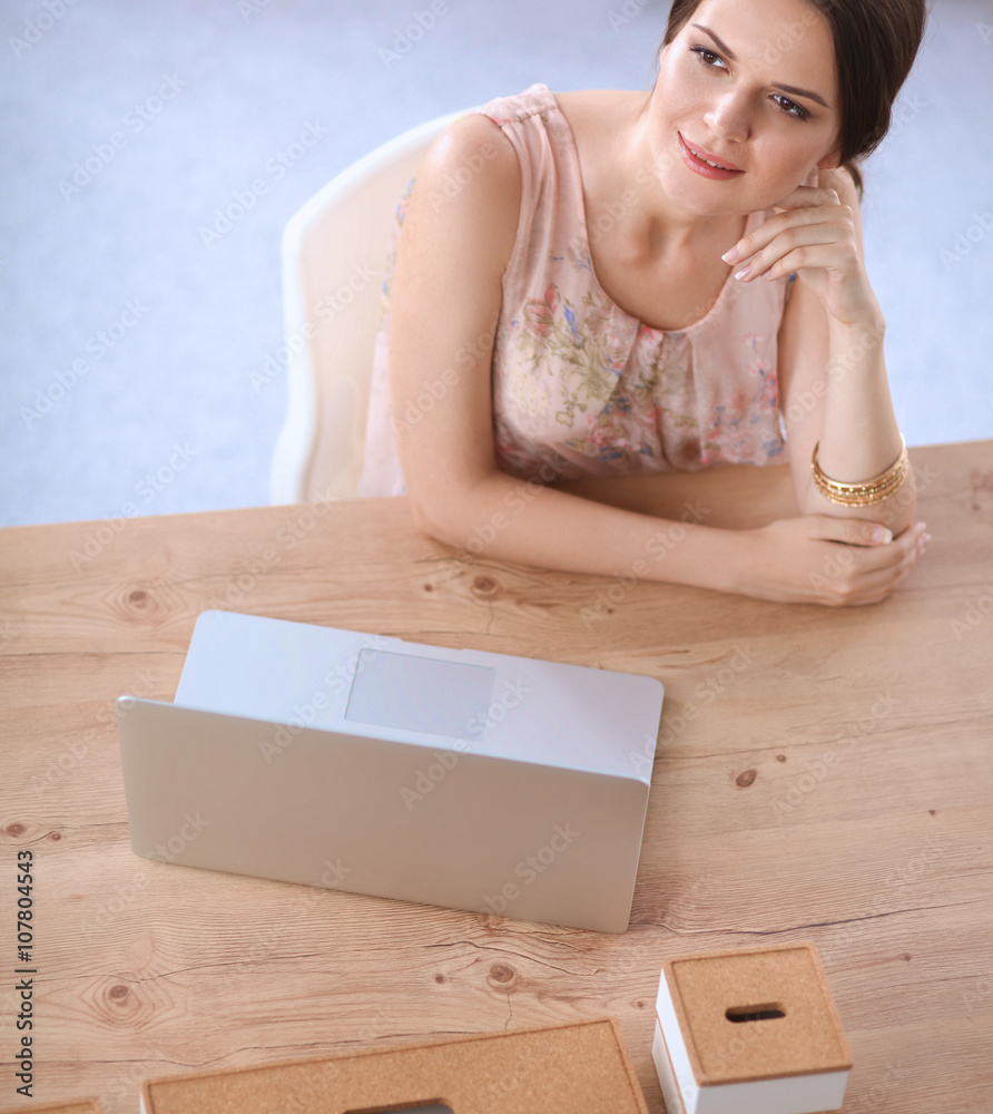 Attractive businesswoman sitting on desk in the office Attractive businesswoman sitting on desk in the office