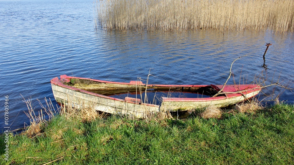 Fototapeta premium Abandoned, old boat at the lakeshore