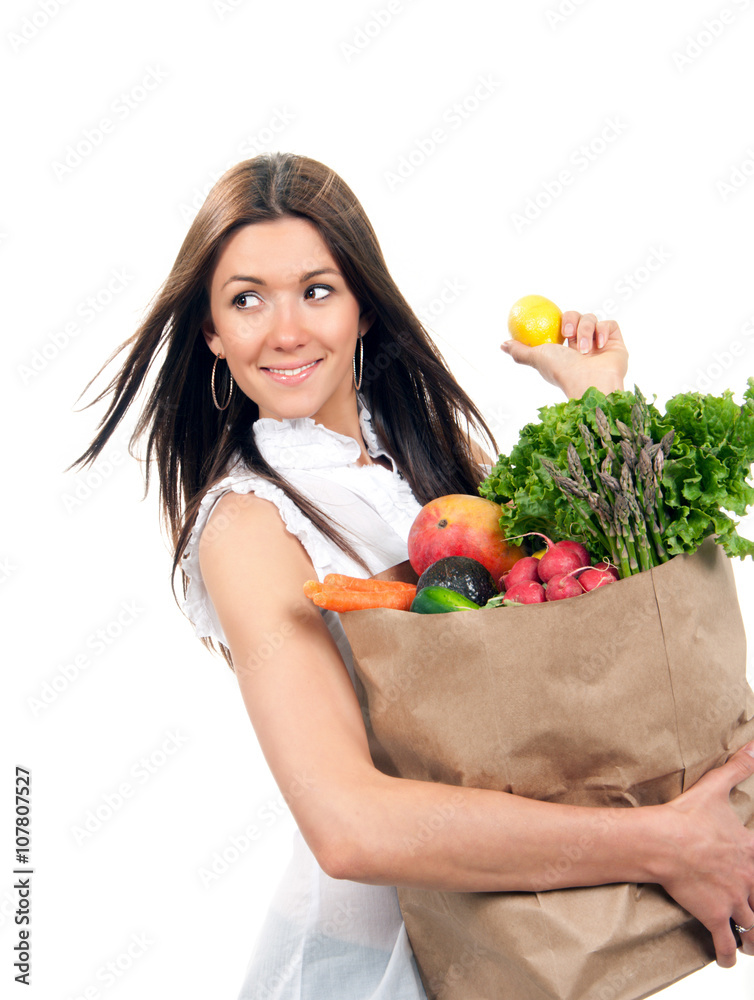 Happy young woman holding a shopping bag full of groceries fruit Happy young woman holding a shopping bag full of groceries fruit
