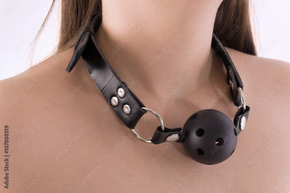 Standing submissive woman with black ball gag in neck. Isolated on white  background. Stock Photo