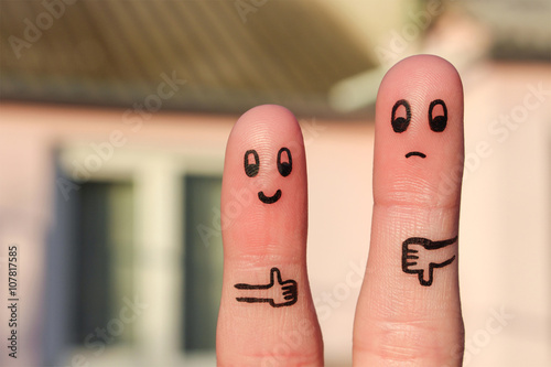 Finger art of couple. Woman showing thumbs up and man showing thumbs down. Concept of disagreement in family.