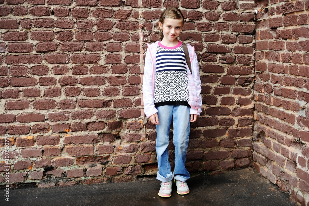 Little kid girl on bricks wall background Little kid girl on bricks wall background