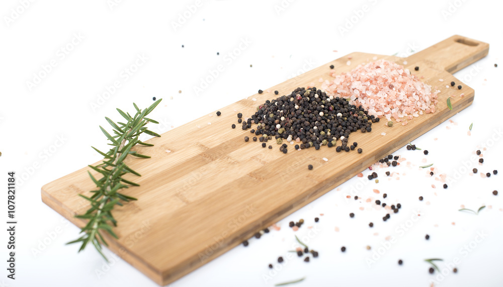 Peppercorns and Himalayan rock salt on a chopping board. Peppercorns and Himalayan rock salt on a chopping board.