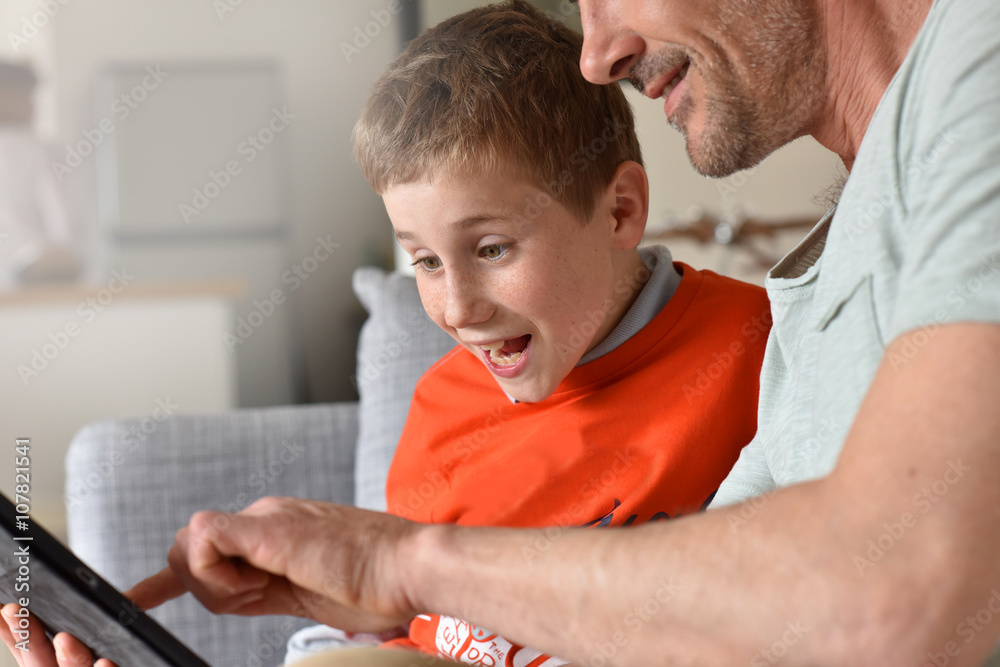 Father and son playing with digital tablet