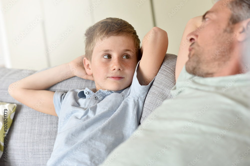 Fototapeta premium Daddy with son relaxing on sofa