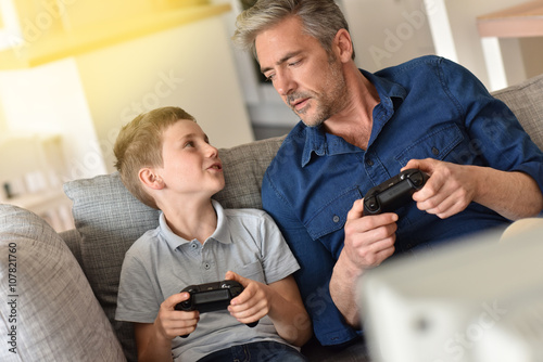 Father and son playing video game on tv