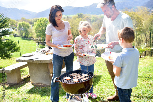 Family having barbecue lunch in garden photo